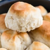 dinner roll stacked on other rolls in a black pan