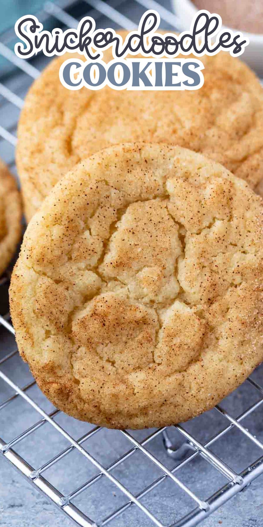 Close-up of homemade snickerdoodle cookies with a cinnamon-sugar coating, resting on a wire cooling rack. The words Snickerdoodles Cookies appear at the top of the image.