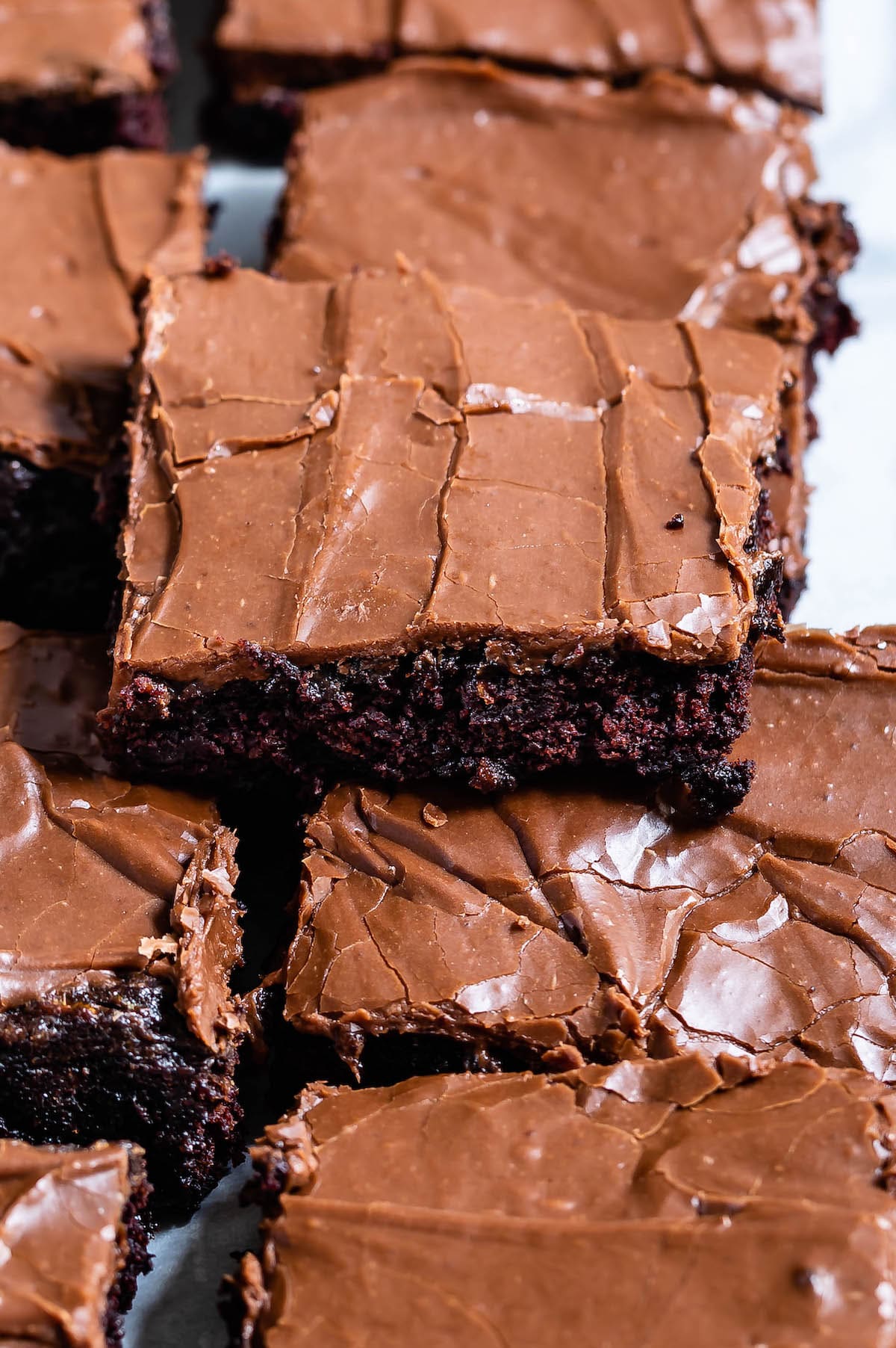 brownie with chocolate frosting sitting on other brownies with words on the photo